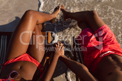 Couple relaxing with hand in hand on the beach