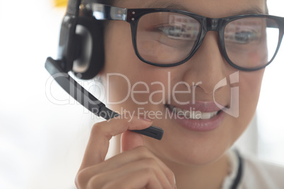 Female customer service executive talking on headset in a modern office