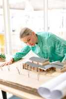 Female architect looking at architectural model