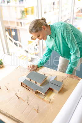 Female architect looking at architectural model