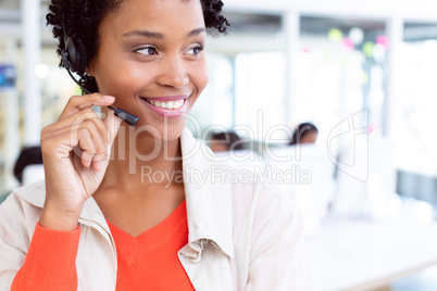 Female customer service executive standing with headset standing in office