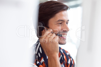 Male customer service executive working on computer at desk