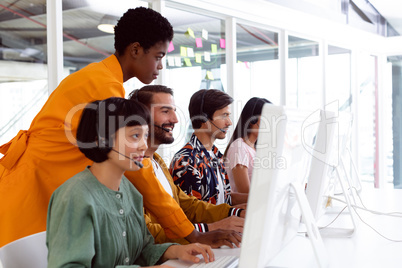 Customer service executive trainer assisting her team at desk