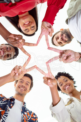 Business people forming star shape with their fingers in a modern office