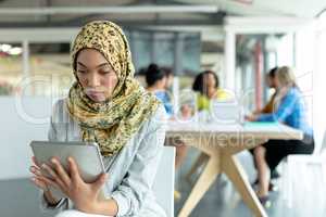 Businesswoman in hijab working on digital tablet at conference room in a modern office