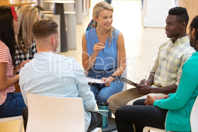 Business people sitting together and having a group discussion in a modern office