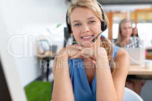 Female customer service executive with headset looking at camera in a modern office