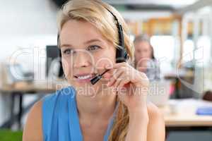 Female customer service executive talking on headset in a modern office