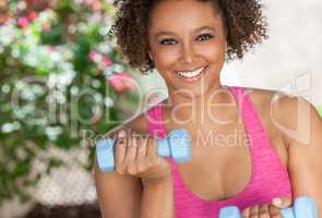 African American Woman Outdoors Exercising With Weights