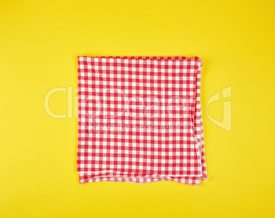 folded red kitchen towel in a cage on a yellow background