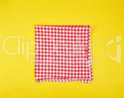 folded red kitchen towel in a cage on a yellow background