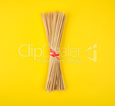 related sharp bamboo sticks barbecue on a yellow background