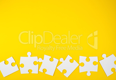 blank white big puzzles on yellow background, flat lay