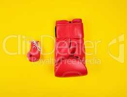 two red boxing gloves on a yellow background