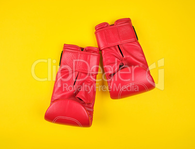 pair of red leather boxing gloves on a yellow  background