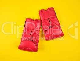 pair of red leather boxing gloves on a yellow  background