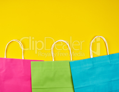 rectangular multi-colored paper shopping bags with white handles