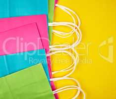 rectangular multi-colored paper shopping bags with white handles