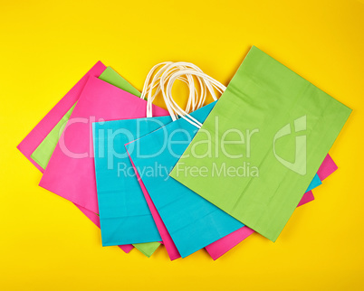 rectangular multi-colored paper shopping bags with white handles