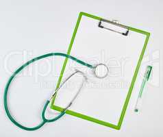 empty white sheets and green medical stethoscope on a white back