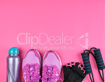 pink women's sneakers, a bottle of water, gloves and a jump rope