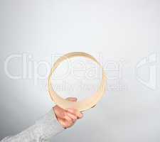 female hands hold round wooden sieve for flour