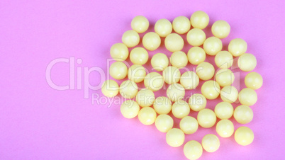 yellow vitamins on pink background