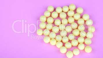 yellow vitamins on pink background