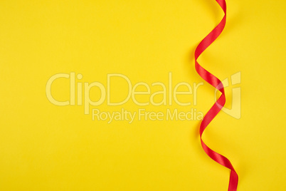 twisted red silk ribbon, yellow background