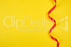 twisted red silk ribbon, yellow background