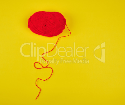 big skein of red wool on a yellow background