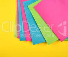 multi-colored paper shopping bags on a yellow background
