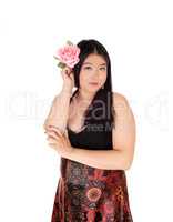 Beautiful Chinese woman holding rose to her hair