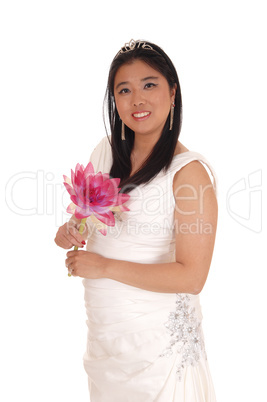 Beautiful bride in a white wedding dress with a lily