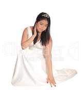 Beautiful bride crouching on the floor in her wedding dress