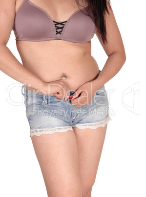 Woman standing from front opening her shorts buttons