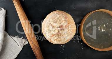round baked bread and wooden old rolling pin