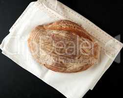 baked oval rye bread on a wooden black board