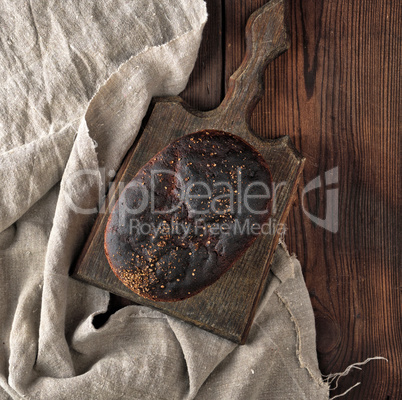 baked rye bread on a gray linen napkin, brown wooden table