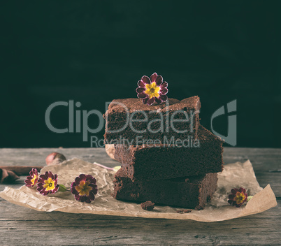 stack of baked square pieces of chocolate brownie cake on brown