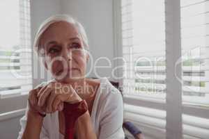 Active senior woman leaning on walking cane and looking away in a comfortable home