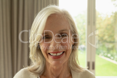 Active senior woman looking at camera in a comfortable home