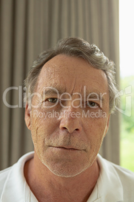 Active senior man looking at camera in a comfortable home