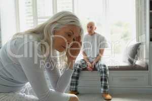 Active senior couple ignoring each other in bedroom