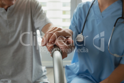 Female doctor consoling active senior man at home