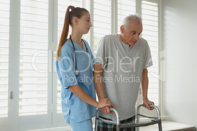 Female doctor helping active senior man to walk with walker