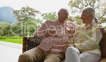 Active senior couple having champagne in the porch