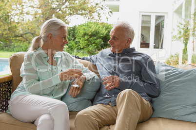 Active senior couple having champagne in the porch