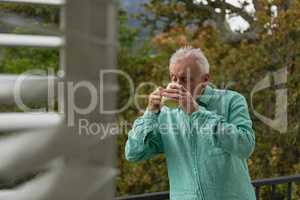 Active senior man drinking coffee on the balcony