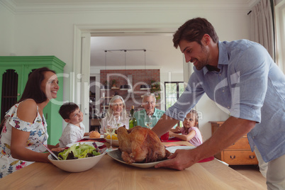 Multi-generation family having food on dining table at home